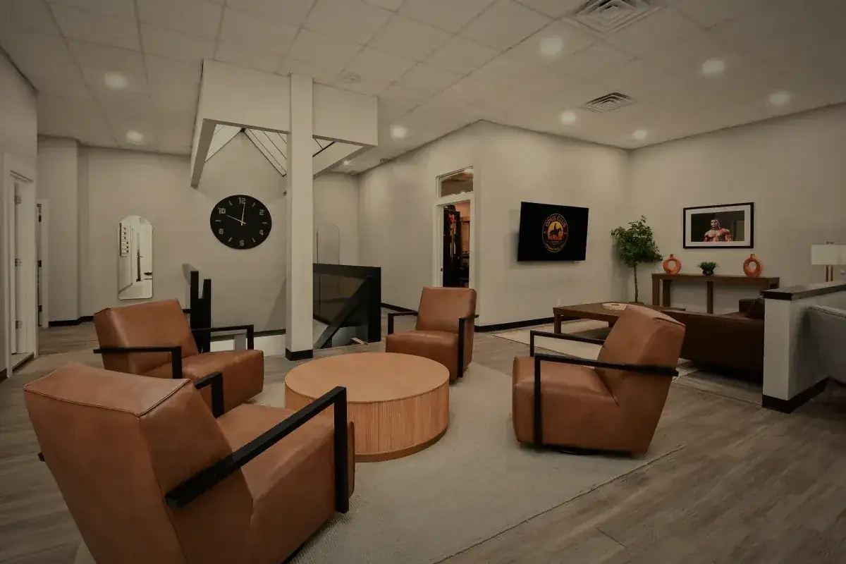 The main floor lounge, leather chairs around a round oak table.