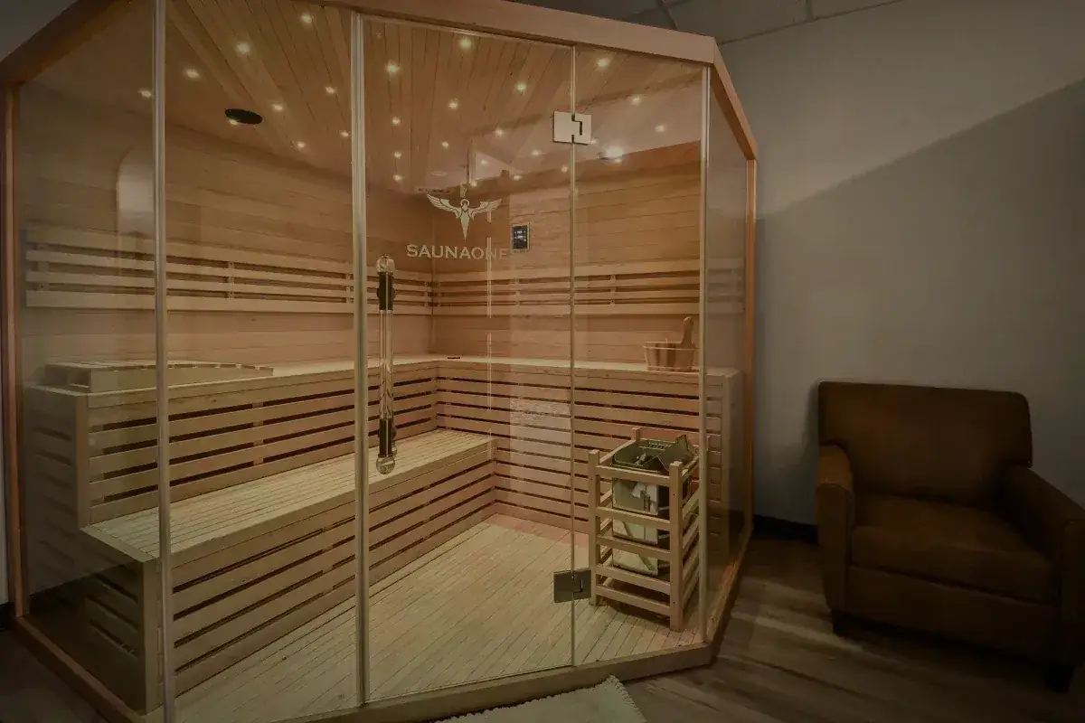 The glass fronted salt sauna with a leather chair beside it.
