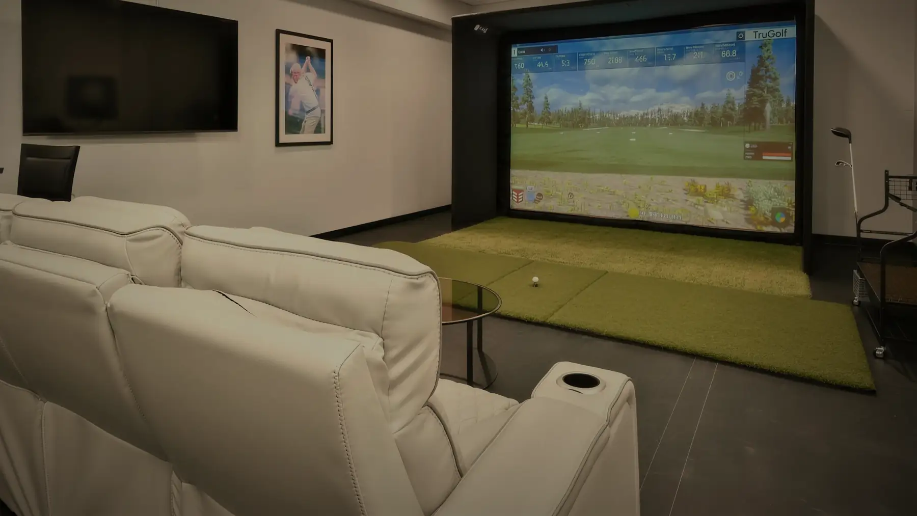 The golf simulator at Opus, seen across the seating with the screen lit.